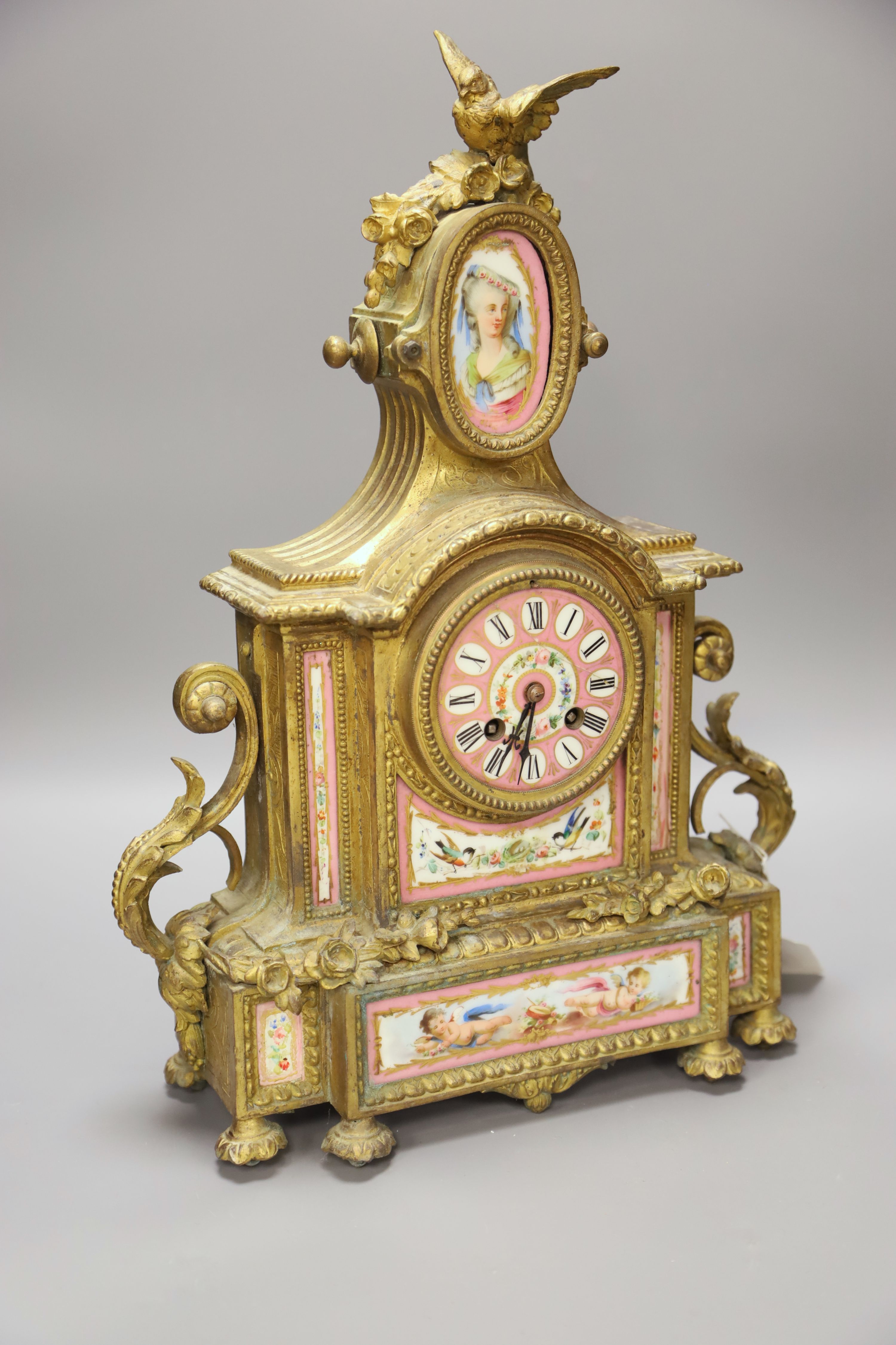 A French gilt metal mantel clock with Sevres-style panels, height 46cm